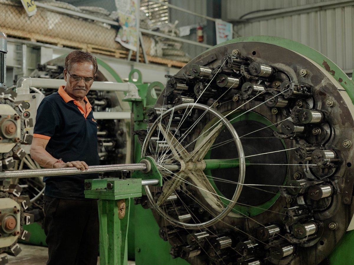 Braiding machine laying wire over a corrugated hose
